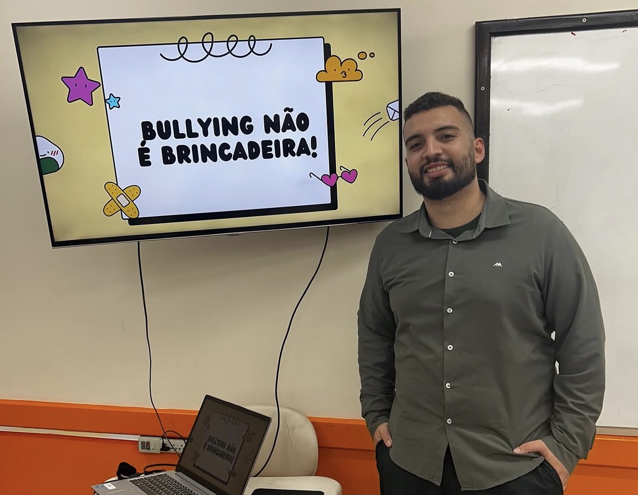 Lucas Montanini ao lado da tela com o tema Bullying não é brincadeira